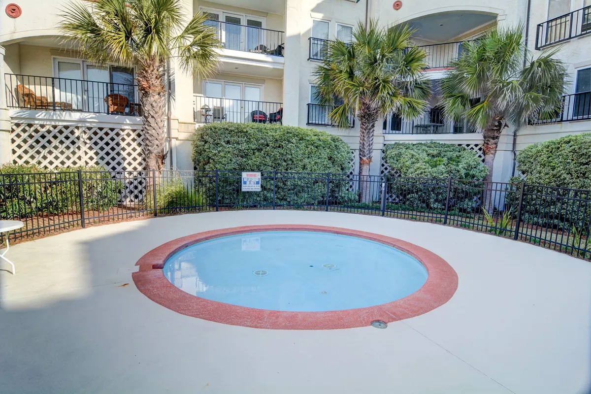 A bubbling hot tub is surrounded by lush palm trees and resort balconies, creating an intimate, tranquil retreat for unwinding after active days. The scene exudes comfort, privacy, and tropical ambiance.
