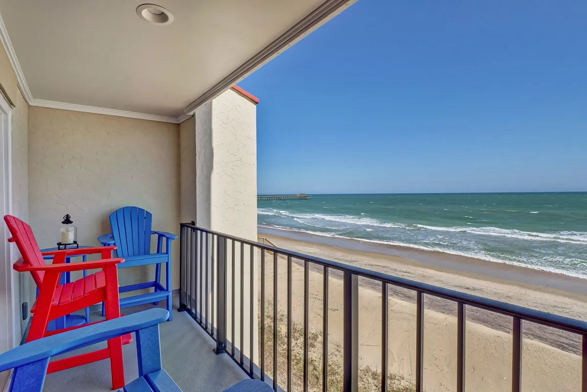 The private terrace, featuring vibrant red and blue chairs perfectly positioned to face the sweeping Atlantic horizon. The terrace provides an intimate spot to enjoy sunrise views, sip morning coffee, or unwind while listening to the waves, all in complete privacy.